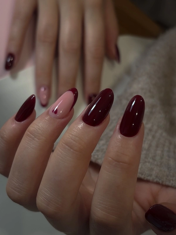 Apperçu des mains d'une cliente avec une pose en nail art french de couleur rouge