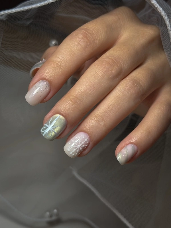 Apperçu des mains d'une cliente avec une pose en nail art hivernal