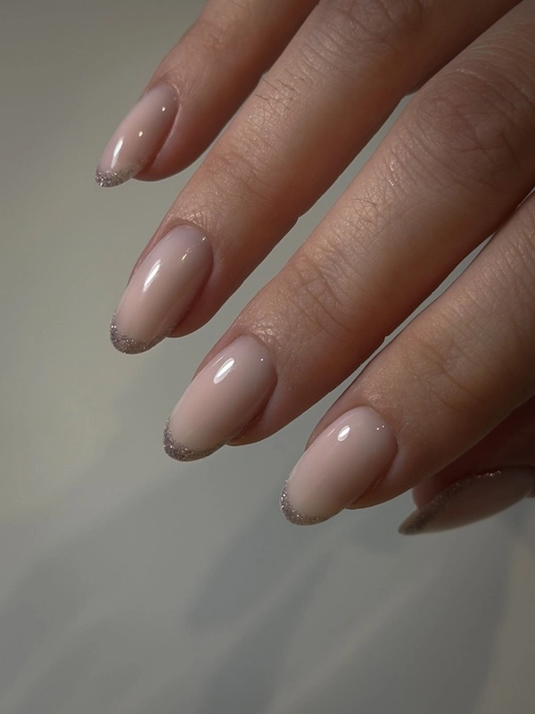 Apperçu des mains d'une cliente avec une pose sur ongles naturels longs